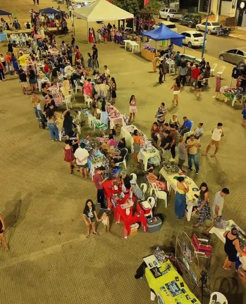 Vista da feira, com barracas e pessoas reunidas na praça